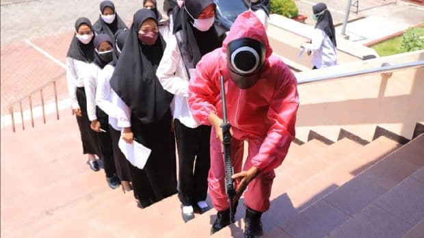مشرف الامتحان يقود المتقدمين إلى قاعة الامتحان